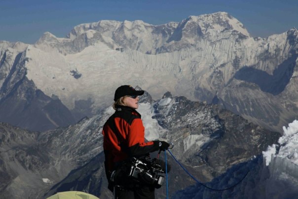 Climber resting on snowy mountain peak